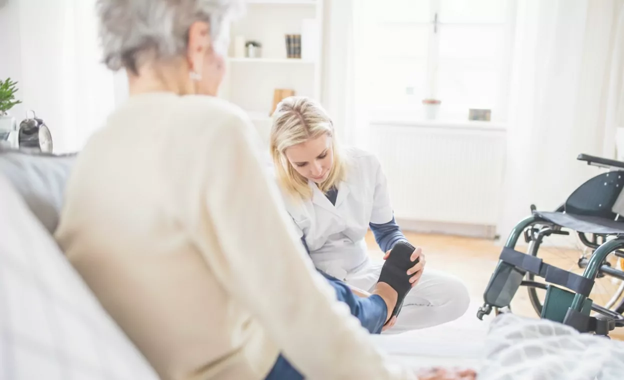Nurse helping a patient with her foot